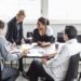 Group of business colleagues discussing at desk in office