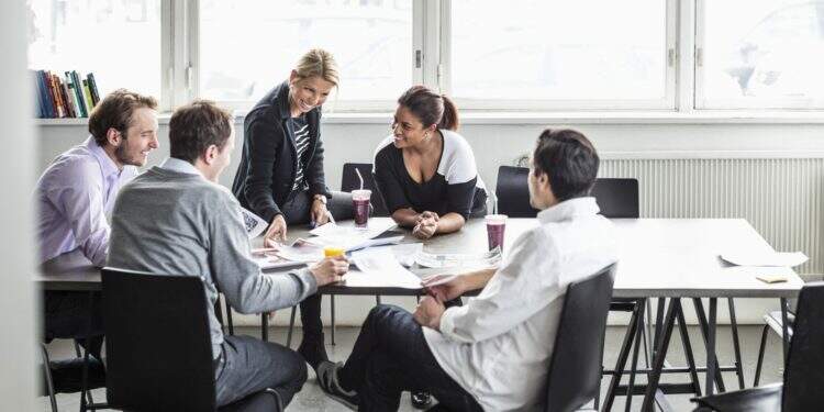Group of business colleagues discussing at desk in office