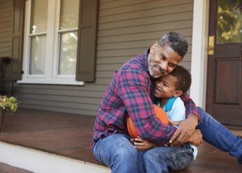 Father And Son Discussing Basketball On Porch Of Home