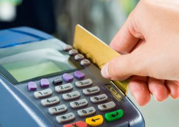 Close-up of payment machine while human hand keeping plastic card in it