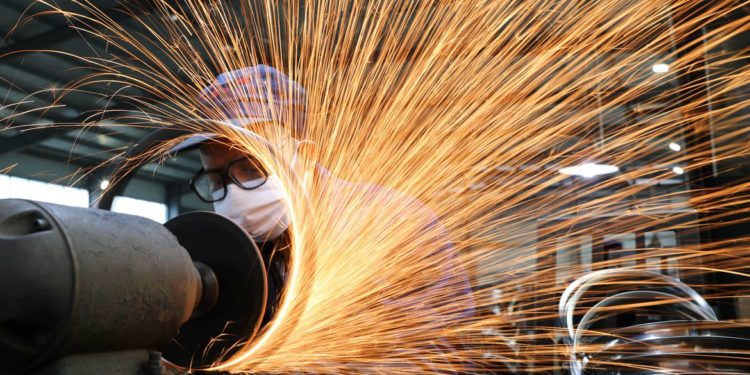 Homem usando máscara de proteção trabalha numa usina siderúrgica. 2/3/2020. China Daily via REUTERS